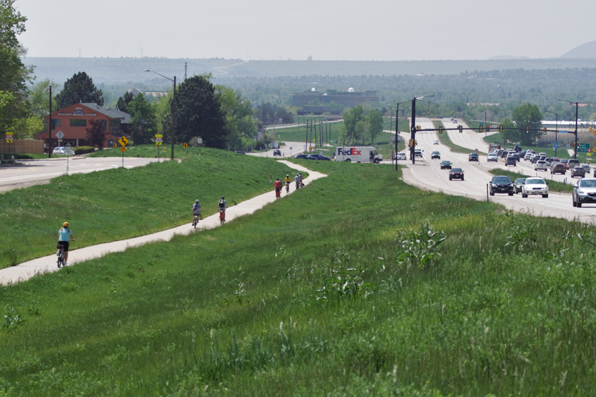 bike commuters on a separated path from the busy road